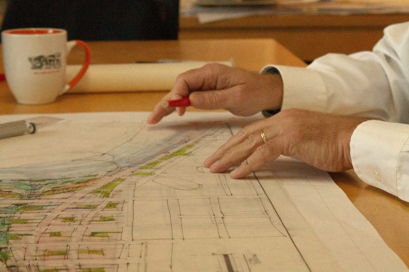 closeup of hands working on architectural drawings